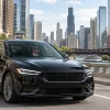 Unbranded black sedan traveling beside the Chicago River